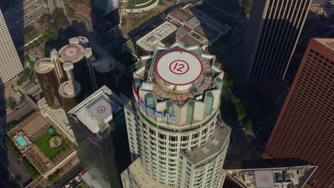 Skyscraper-rooftop-helicopter-landing-pad-in-Downtown-Los-Angeles-Skyline,-Birds-Eye-Overhead-Top-Down-View-from-above