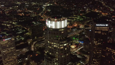 Scenic-Wide-View-of-Skyscrapers-in-Big-City-at-Night-with-lit-up-illuminated-Buildings-in-Los-Angeles-Skyline,-Aerial-Drone-rising-shot,-Circa-2019