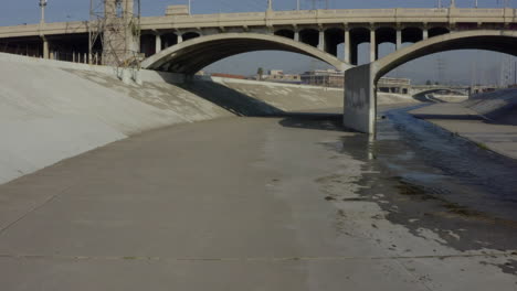 AERIAL:-Under-LA-River-bridge,-Los-Angeles,-California,-Daylight