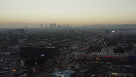 AERIAL:-Over-Shopping-Street-Fairfax-Los-Angeles,-California,-at-Sunset