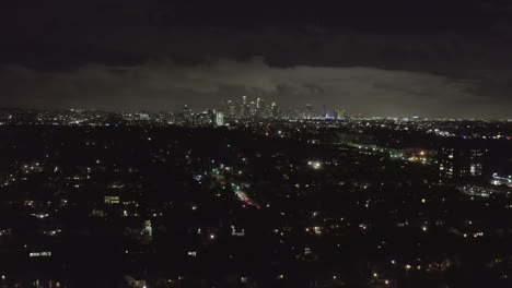 Antena:-Sobre-El-Oscuro-Hollywood-Los-Angeles-Por-La-Noche-Con-Nubes-Sobre-El-Centro-Y-Las-Luces-De-La-Ciudad