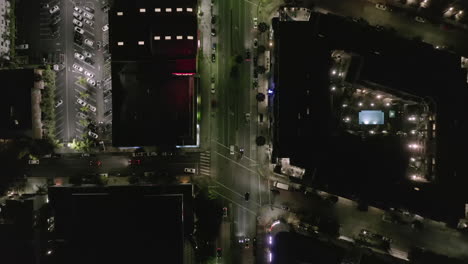 AERIAL:-Overhead-View-on-Wilshire-Boulevard-Street-in-Hollywood-Los-Angeles-at-Night-with-Glowing-Streets-and-City-Car-Traffic-Lights