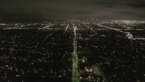 Luftbild:-Blick-über-Los-Angeles-Bei-Nacht-Mit-Wilshire-Boulevard-Leuchtenden-Straßen-Und-Stadtautoampeln