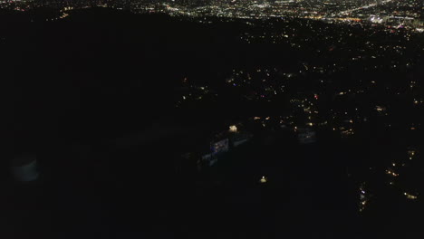 Antenne:-Langsame-Neigungsbewegung-über-Hollywood-Hügel-Bei-Nacht,-Die-Die-Lichter-Der-Stadt-Los-Angeles-Enthüllt