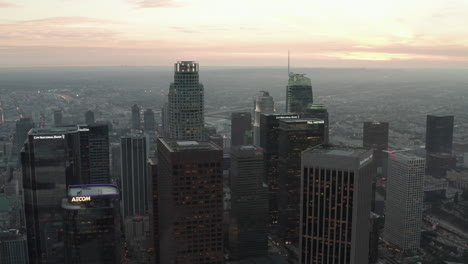 AERIAL:-Breathtaking-wide-shot-backing-up-from-Downtown-Los-Angeles,-California-Skyline-at-Sunset