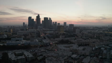 Luftaufnahme:-Filmische-Ansicht-Der-Geschäftigen-Innenstadt-Von-Los-Angeles-Direkt-Nach-Einbruch-Der-Dunkelheit-Mit-Den-Lichtern-Der-Skyline-Und-Dem-Autoverkehr