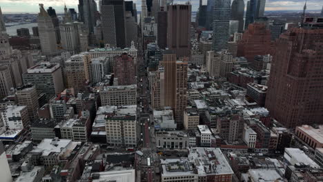 Aerial-footage-of-high-rise-downtown-buildings.-Wide-straight-street-between-skyscrapers.-Manhattan,-New-York-City,-USA