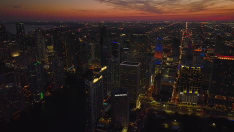 Breath-taking-twilight-city-scene.-Fly-above-town-after-sunset,-tilt-down-n-modern-tall-downtown-buildings.-Miami,-USA