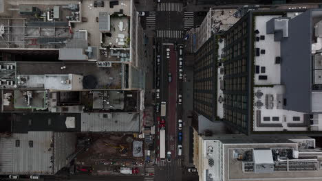 Aerial-birds-eye-overhead-top-down-panning-footage-of-street-and-crossroads-between-tall-buildings.-Tracking-of-cars.-Manhattan,-New-York-City,-USA