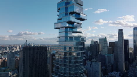 Slide-and-pan-shot-of-futuristic-modern-designed-tall-office-building.-Jenga-Tower-with-glass-facade-and-terraces.-Manhattan,-New-York-City,-USA
