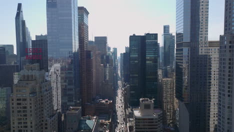 Elevated-view-of-long-straight-wide-street-between-tall-modern-downtown-skyscrapers.-7th-Avenue-from-north.-Manhattan,-New-York-City,-USA