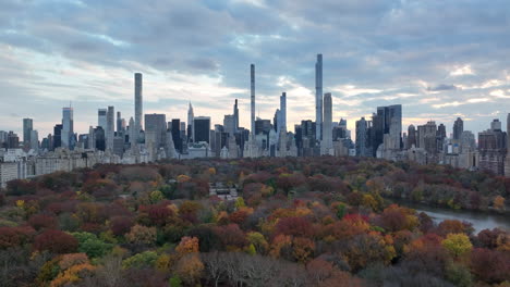 Wide-panoramic-view-of-downtown-high-rise-buildings-against-cloudy-sky.-Colourful-trees-in-Central-park.-Manhattan,-New-York-City,-USA