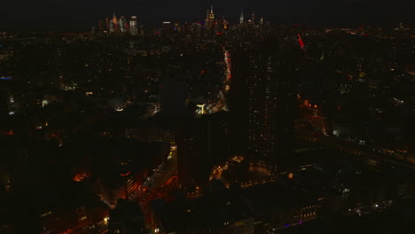 Absteigende-Luftaufnahme-Der-Nachtstadt.-Beleuchtete-Wolkenkratzer-In-Der-Innenstadt-Im-Hintergrund.-Manhattan,-New-York-City,-Vereinigte-Staaten