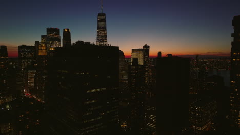 Slide-and-pan-elevated-footage-of-modern-tall-office-skyscrapers-in-financial-district-against-colourful-twilight-sky.-Manhattan,-New-York-City,-USA