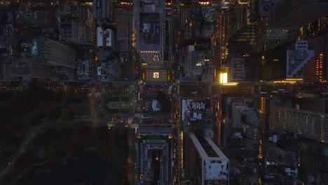 Aerial-birds-eye-overhead-top-down-view-of-evening-downtown.-Illuminated-streets-and-high-rise-office-buildings.-Manhattan,-New-York-City,-USA