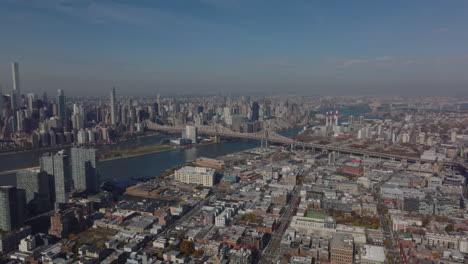 Slide-and-pan-aerial-footage-of-Queensboro-Bridge.-Various-development-in-urban-boroughs,-low-residential-buildings-and-tall-business-skyscrapers.-New-York-City,-USA