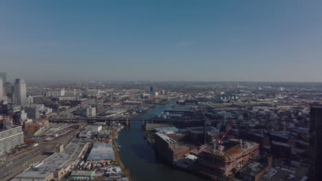 Aerial-panoramic-view-of-large-city.-Fly-around-tall-skyscrapers-in-construction.-Long-Island-City-train-station-and-development-along-Newtown-Creek.-New-York-City,-USA