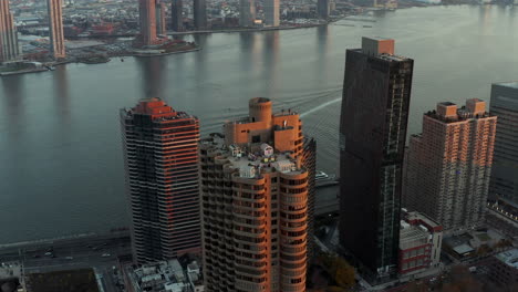 Fly-around-group-of-high-rise-apartment-houses-on-East-River-waterfront.-Aerial-view-of-city-at-sunset.-Manhattan,-New-York-City,-USA