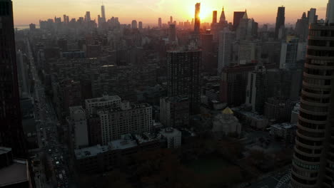 High-angle-view-of-town-development.-Tilt-up-reveal-of-skyline-against-setting-sun.-Manhattan,-New-York-City,-USA